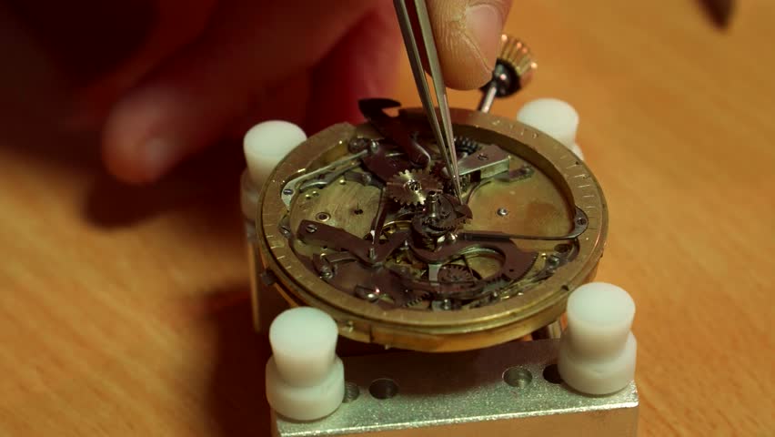 Watchmaker delicately places cogwheel into intricate repeater mechanism