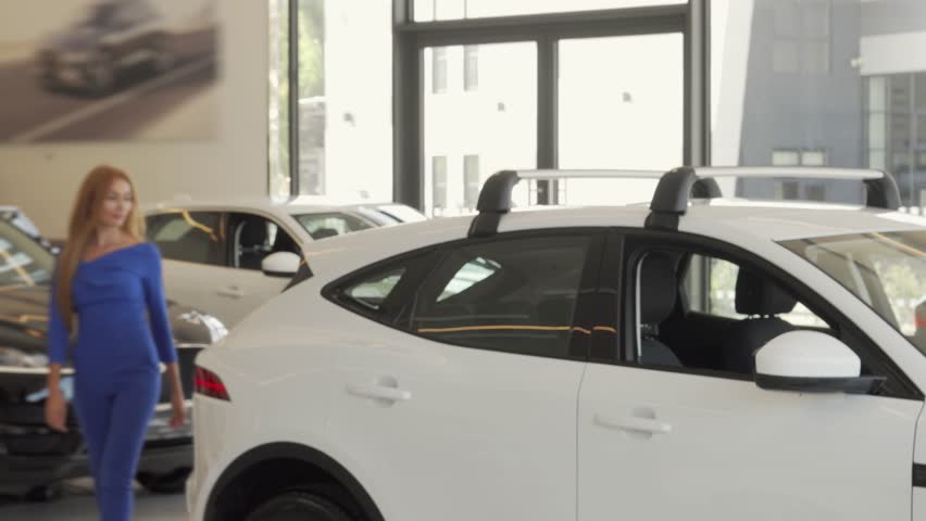 Elegant woman selecting her dream car at a stylish auto dealership