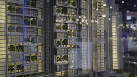 Miniature model of modern multi-storey house with decorative trees adorning balconies. Real estate exhibition presents apartment building with glass facade offering panoramic views - Powered by Shutterstock - Get 15% off with code: PIKWIZARD15