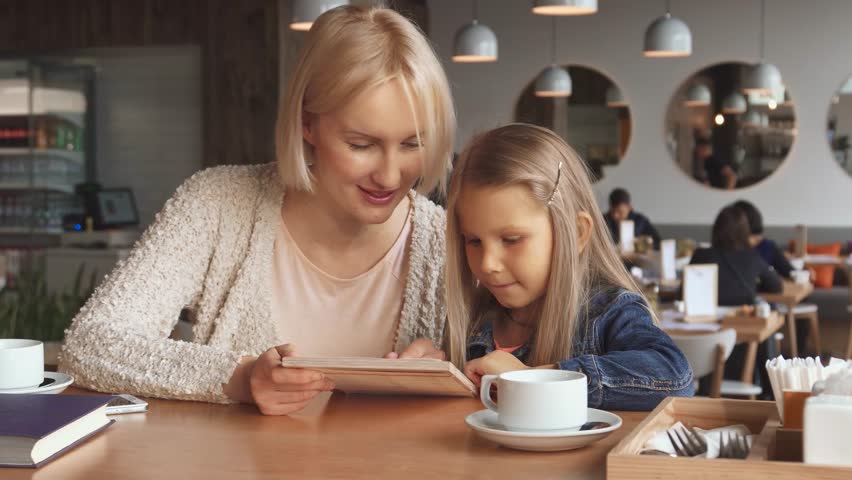 Mother and daughter share a delightful moment over the menu