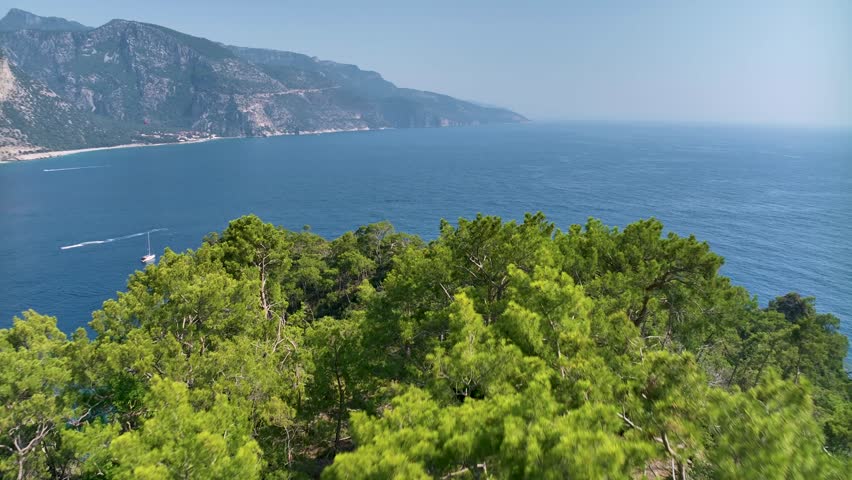 Wonderful aerial view of a gulet entering the amazing oludeniz lagoon, fethiye, turkey, with its turquoise waters and white sand beach surrounded by green lush vegetation
