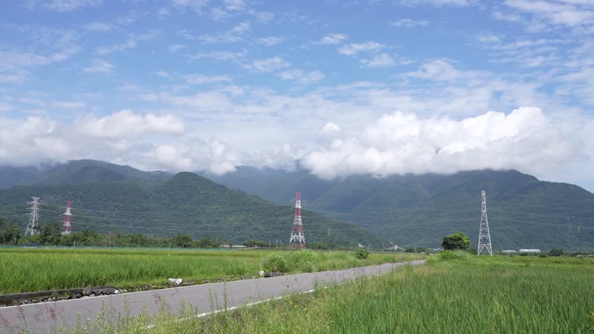 Timelapse of Country Road Through Rice Fields with Mountains and Moving Clouds