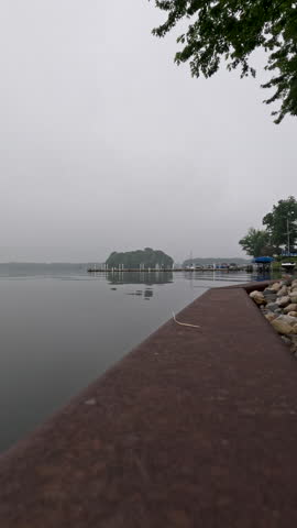 Retaining Wall Protects Lake Property. Surface level view of a sturdy retaining wall dividing the lake from the land. A retaining wall is used to protect land from soil erosion.