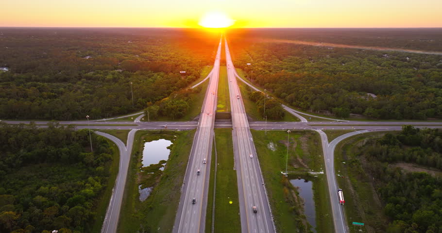Sunrise over multilane freeway system in Florida with fast moving cars and trucks traveling the I-75 highway
