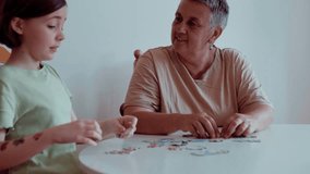 Grandmother and granddaughter doing puzzle at home. - Powered by Shutterstock - Get 15% off with code: PIKWIZARD15