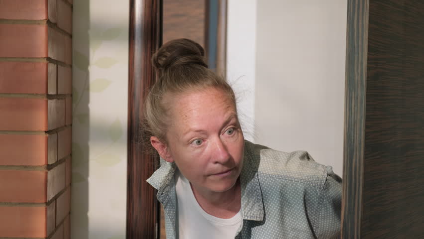 Woman opens closed door to room and looks around