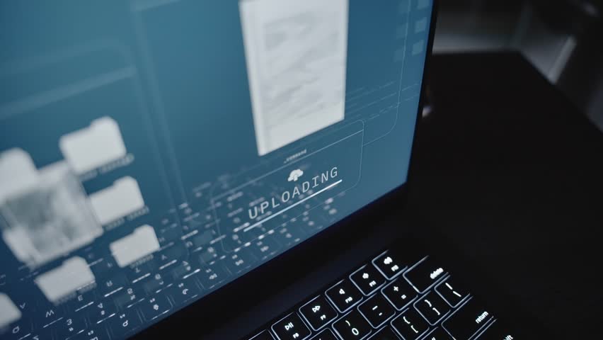Close up on laptop computer screen uploading top secret documents to server. Online remote connection stealing government classified confidential information files copying to cloud by spy or insider