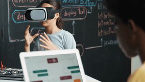African boy programming system while caucasian girl enter metaverse while sitting at blackboard with engineering code written.high school girl wearing VR or headset in STEM technology. Edification - Powered by Shutterstock - Get 15% off with code: PIKWIZARD15
