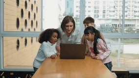 Happy caucasian teacher and multiethnic children waving hands to camera in casual uniform. Smart mentor and diverse student looking at laptop while greeting by moving hands or say good bye. Erudition. - Powered by Shutterstock - Get 15% off with code: PIKWIZARD15