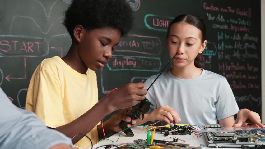 Young student fixing controller while teacher programming engineering code at STEM class. Closeup of instructor hand typing computer while smart girl using electronic tool and blackboard. Edification - Powered by Shutterstock - Get 15% off with code: PIKWIZARD15