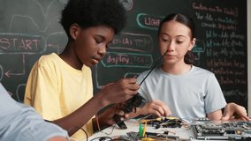 Young student fixing controller while teacher programming engineering code at STEM class. Closeup of instructor hand typing computer while smart girl using electronic tool and blackboard. Edification - Powered by Shutterstock - Get 15% off with code: PIKWIZARD15