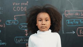 Happy african student smiling and standing at board with engineering prompt or coding, programing system written in STEM technology classroom. Child present science theory or innovative. Erudition. - Powered by Shutterstock - Get 15% off with code: PIKWIZARD15