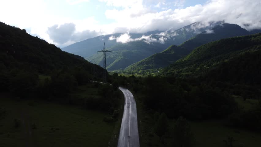 top view of foggy mountains with river and roadway 