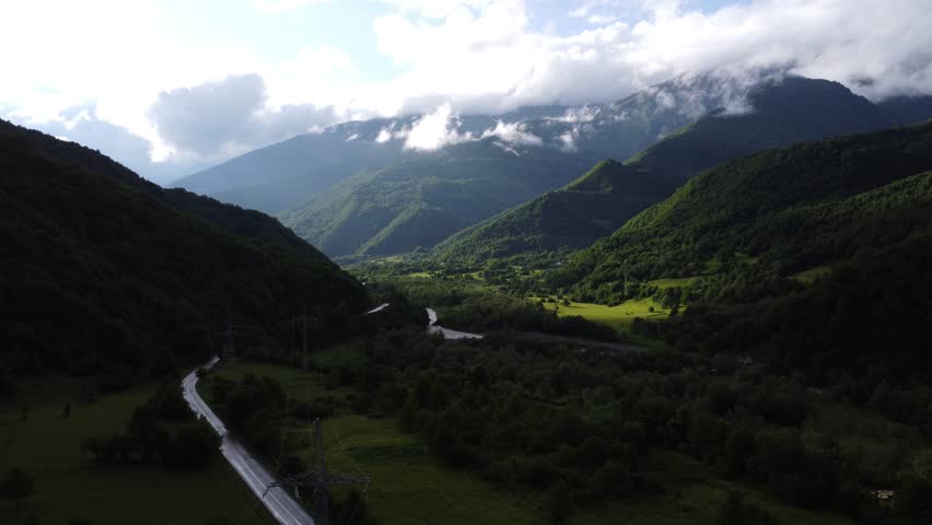 top view of foggy mountains with river and roadway 