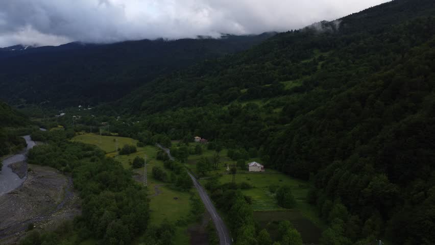 top view of foggy mountains with river and roadway 