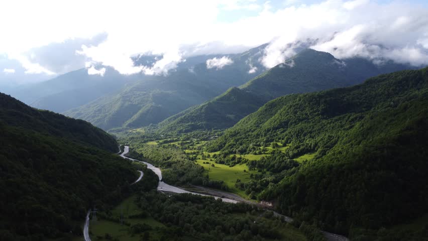 top view of foggy mountains with river and roadway 