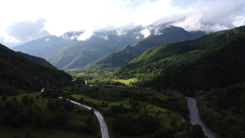 top view of foggy mountains with river and roadway 
