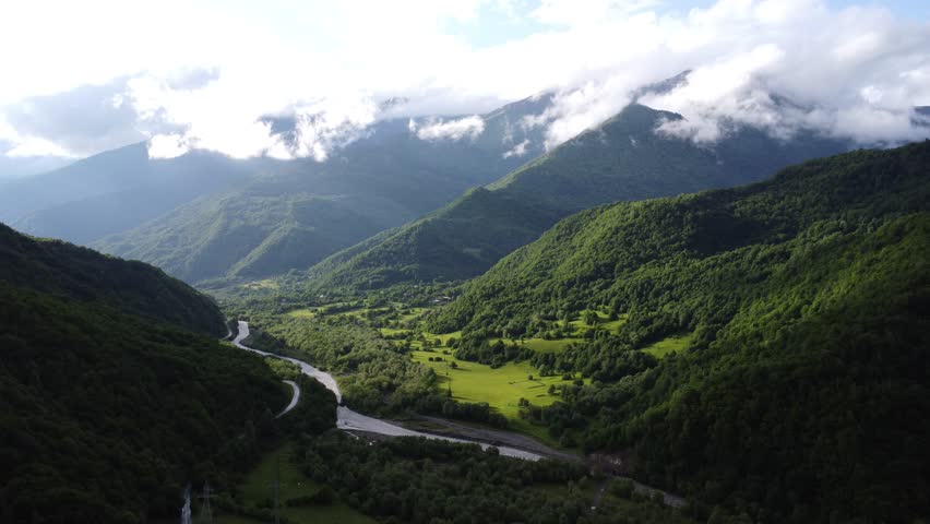 top view of foggy mountains with river and roadway 