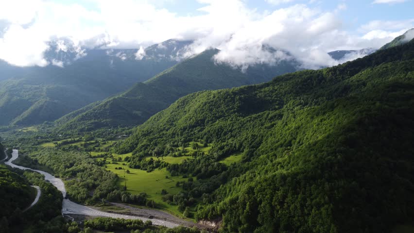 top view of foggy mountains with river and roadway 