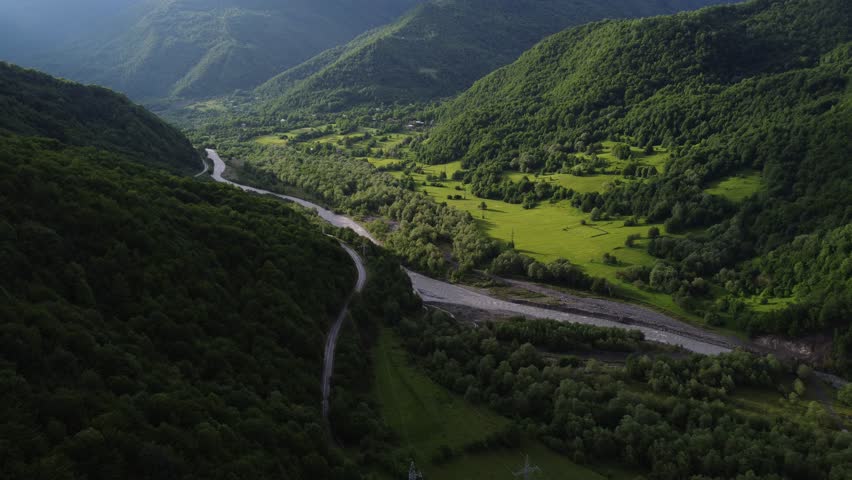 top view of foggy mountains with river and roadway 