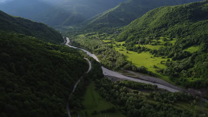 top view of foggy mountains with river and roadway 