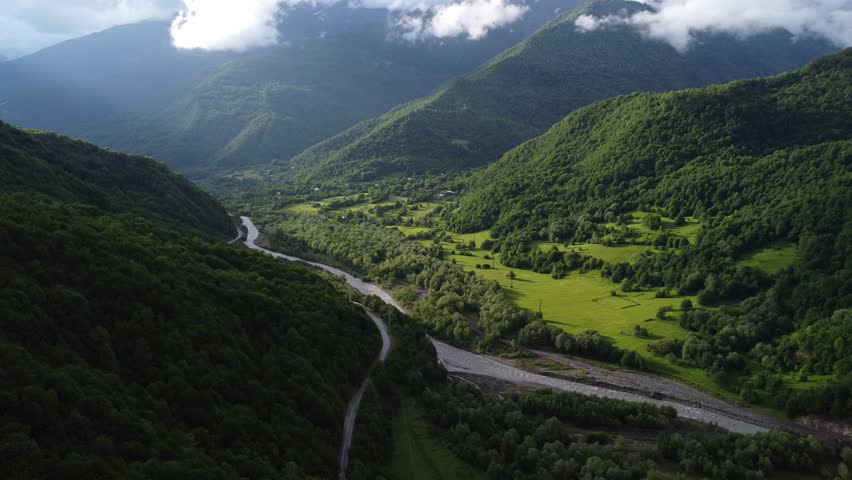 top view of foggy mountains with river and roadway 