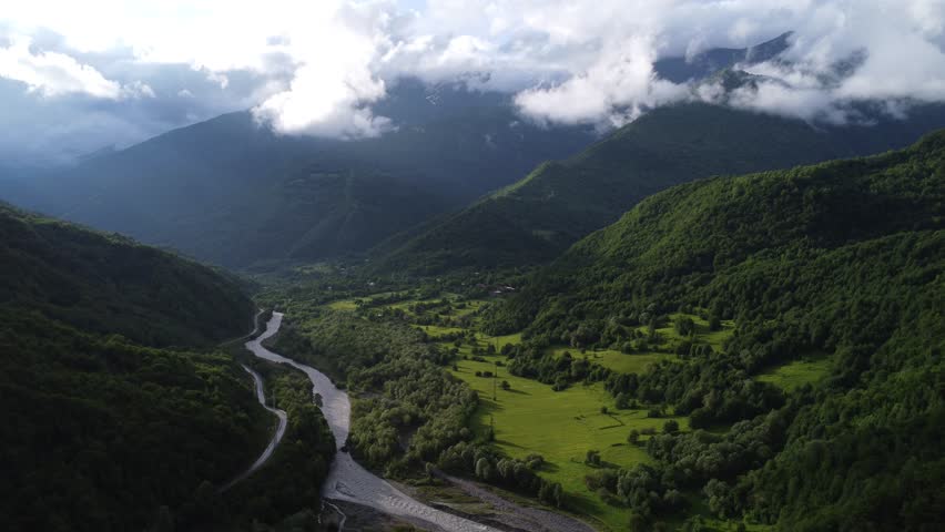 top view of foggy mountains with river and roadway 