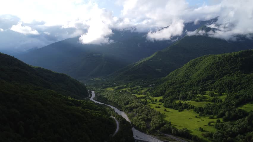 top view of foggy mountains with river and roadway 
