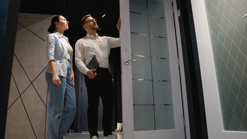 Consultant showing door to couple in furniture store