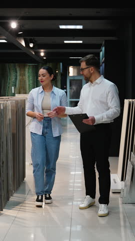 Consultant advising customer choosing tiles in showroom