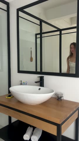 Woman in bathroom look in mirror with anxious sight. Mental problems of feeling drained, overwhelmed, low energy, burnout. Mental health and psychology help concept.