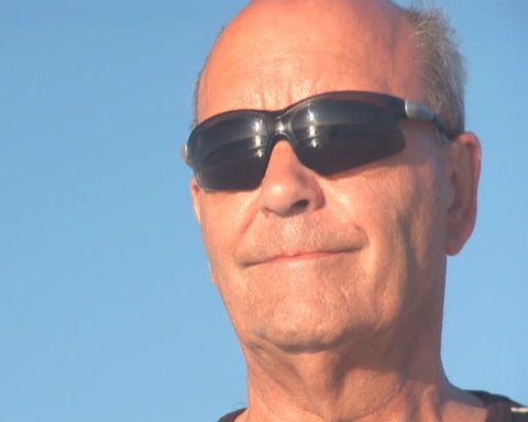 PAL: Senior man with reflection of ocean in sunglasses