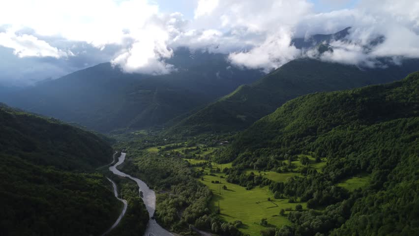 top view of foggy mountains with river and roadway 