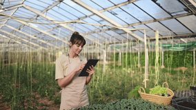 Female farmer using tablet in greenhouse, checking plants - Powered by Shutterstock - Get 15% off with code: PIKWIZARD15