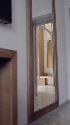 Dolly push through oak-framed arch to bright hallway mirror, showcasing stone floor, curved lines and sunlit palette — perfect transitional shot for premium real-estate promos.