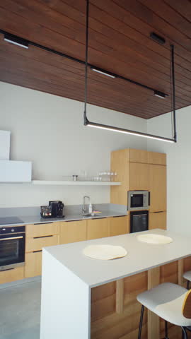 White quartz island to reveal vertical oak cabinets and suspended black frame shelf. Clean geometry embodies Nordic restraint for cooking shows or appliance adverts.