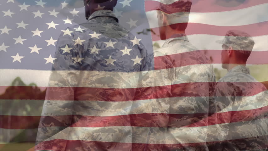 Three soldiers standing on military base, wind lifting flag while rightmost soldier saluting flag. Patriotism, discipline, unity, bravery, outdoor, nature, reverence