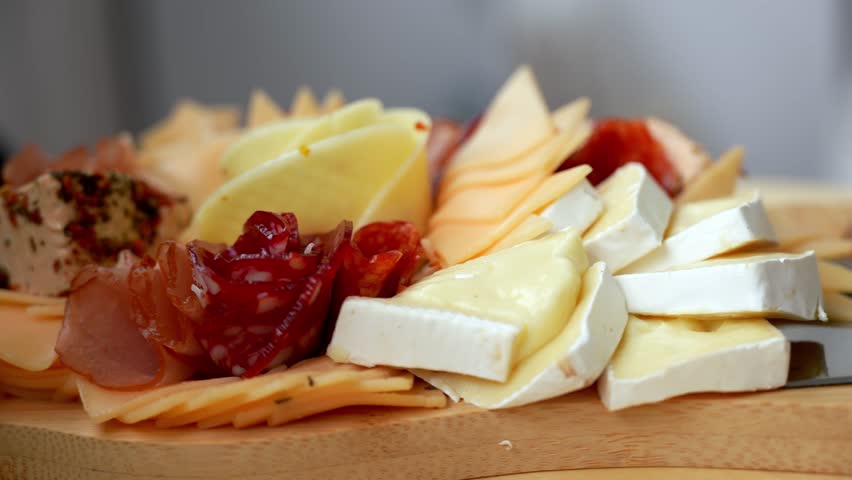 Food trend gift aperitivo party idea. Appetizers wooden grazing board with different antipasti charcuterie snacks and cheese. Assorted cheese meat platter. Disordered eating