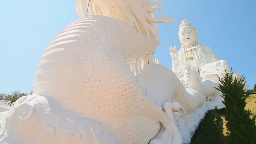 Giant Guan Yin statue with white dragon staircase at Wat Huay Pla Kang Chiang Rai Thailand. Buddhist spiritual site, religious architecture, compassion symbol, cultural heritage, tourism