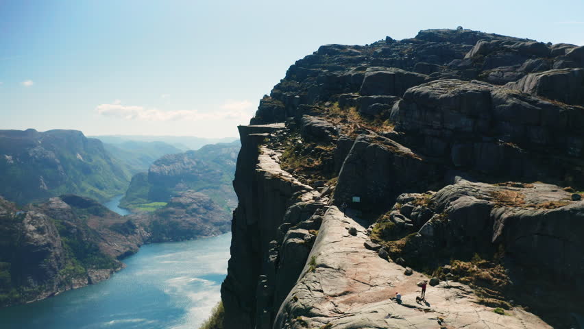 Breathtaking view of Preikestolen with dramatic cliff face overlooking Lysefjord. Majestic scale of natural landmark and waters of fjord in Norway