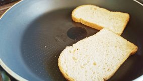 toasts are fried in a frying pan. Two slices of white bread toasting in a non-stick frying pan. The start of a simple homemade breakfast or sandwich preparation, captured in a clean and bright kitchen - Powered by Shutterstock - Get 15% off with code: PIKWIZARD15