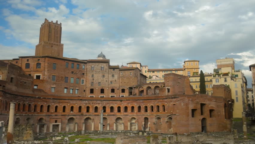 Ancient Roman ruins of the markets and forum, with historical buildings under a cloudy sky in Rome
