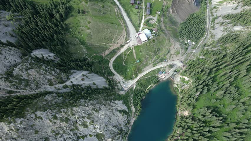 A stunning view of Kolsai Lake in Kazakhstan, located in the Tien Shan Mountains near the border with Kyrgyzstan. Surrounded by dense pine forests and majestic peaks