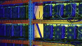 Multiple ASIC bitcoin miners with prominent cooling fans and tangled wiring mounted on metal shelves in a server rack. Close up pan right - Powered by Shutterstock - Get 15% off with code: PIKWIZARD15