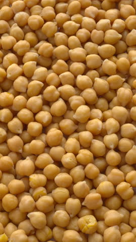 Cooked chickpea or garbanzo bean background. It is one of the earliest cultivated legumes. Table spin. Vertical video.