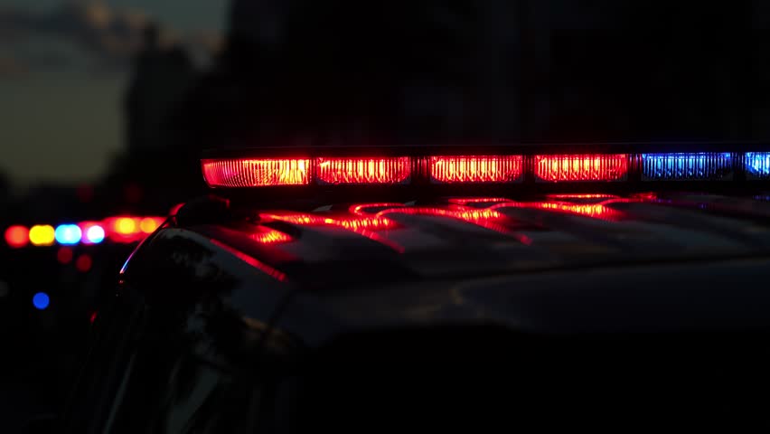Police car flashing. Crime scene at night. Patrol vehicle outdoors. Emergency lights glowing. Flashing police siren. Police car vehicle. Law enforcement. City night patrol. Police arrest.