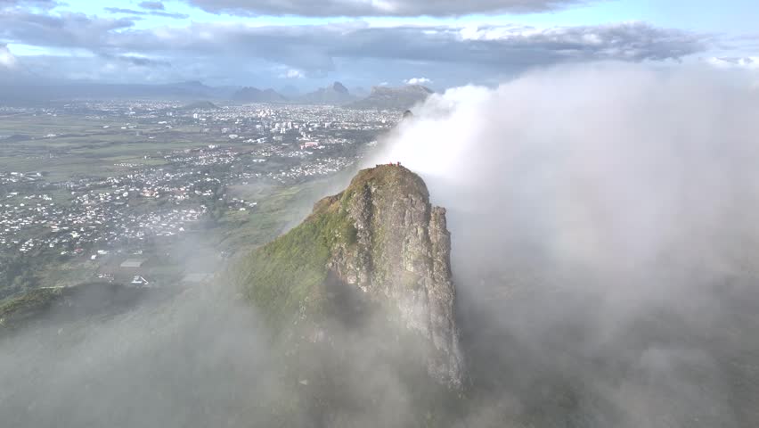 Aerial view of Le Pouce mountain surrounded by clouds and urban cityscape, Moka, Port Louis, Mauritius.