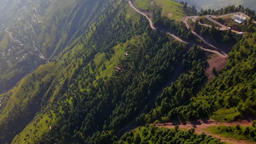 Aerial view of beautiful green mountains and forested valleys with a winding road, Muzaffarabad, Azad Jammu Kashmir, Pakistan.