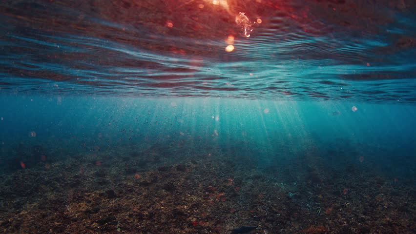 Underwater view of the sea surface with sun rays in the Maldives
