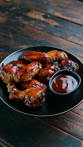 Mouthwatering BBQ chicken wings, coated in a rich sauce, perfect for finger-licking appetizers at any gathering. 